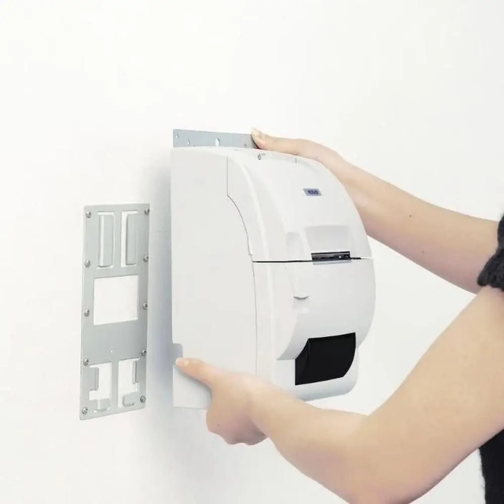 Person montiert weißen Papierhandtuchspender an Wand