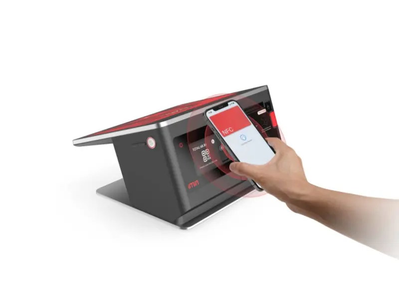 Hand hält Smartphone an NFC-Zahlterminal