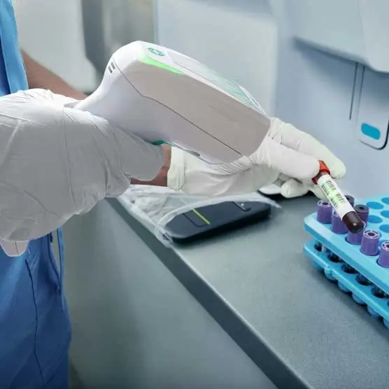 Labortechniker scannt Blutprobe mit mobilen Barcode-Scanner