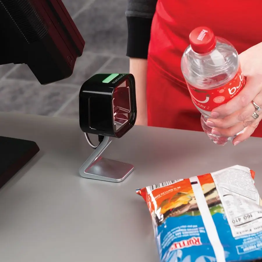 Mitarbeiter scannt Ware mit stationärem Barcode-Scanner